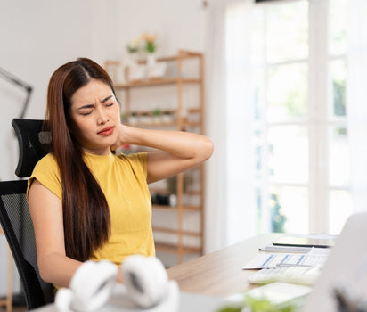 Woman with morning joint stiffness at her desk — collagen supports joint comfort and mobility