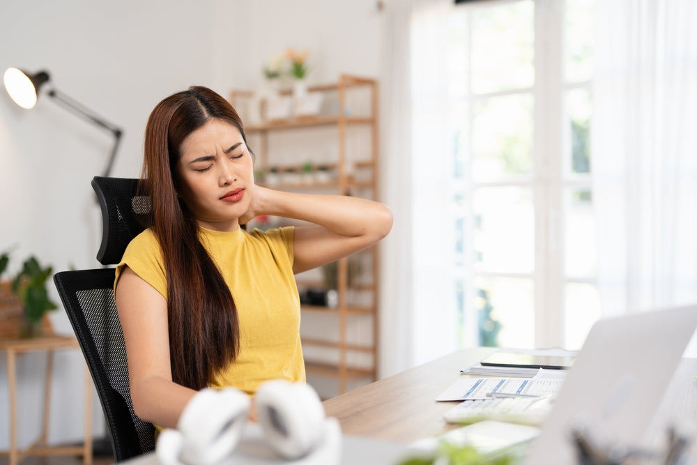 Woman with morning joint stiffness at her desk — collagen supports joint comfort and mobility