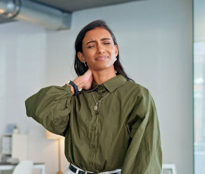 Woman in olive shirt holding her stiff neck — glucosamine and collagen support joint pain and cartilage health