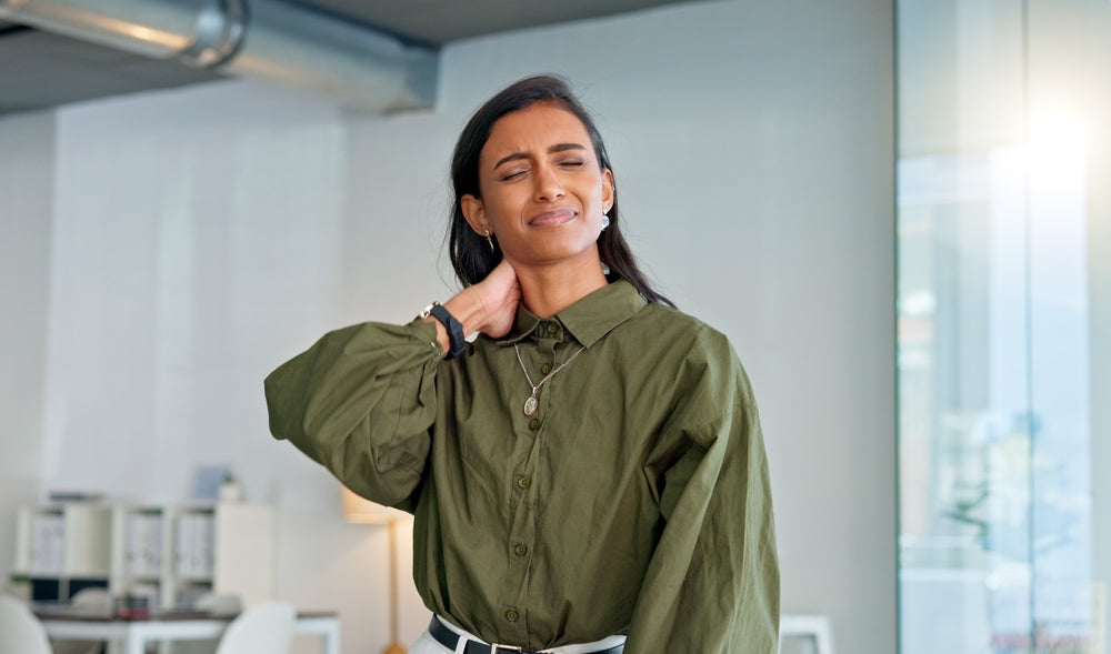 Woman in olive shirt holding her stiff neck — glucosamine and collagen support joint pain and cartilage health