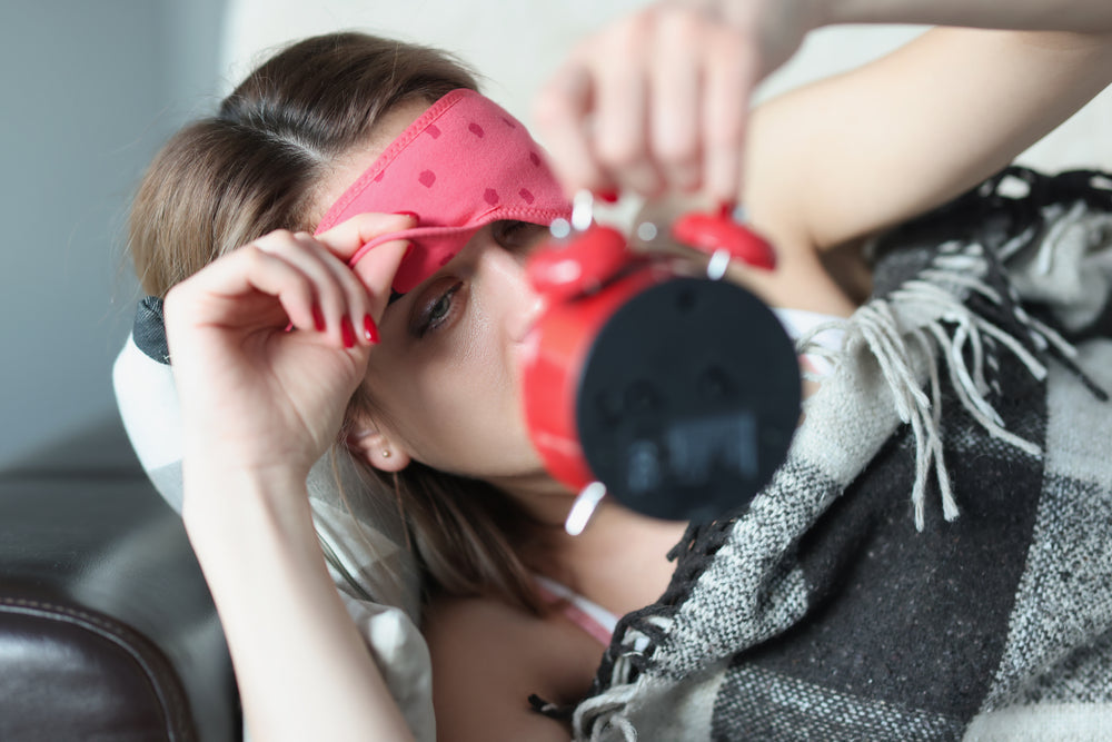 Magnesium supports better sleep — woman lifting sleep mask to check alarm clock at 3am