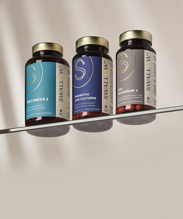 Four Swallow supplement bottles on a metallic surface with a neutral background